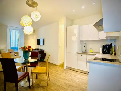 a kitchen and dining room with a table and a dining room at Apartment Massena in Nice