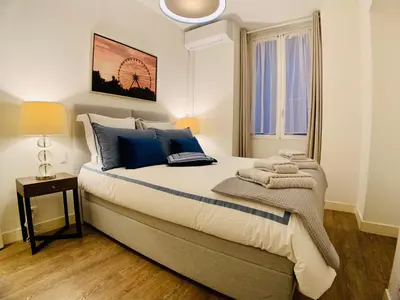 a bedroom with a large bed with blue pillows at Apartment Massena in Nice