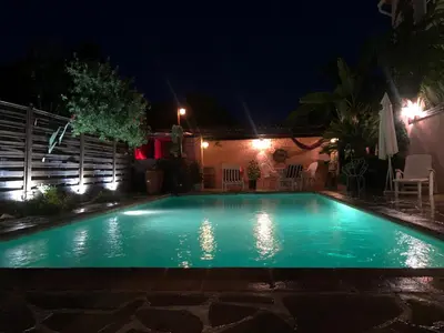 a swimming pool in a yard at night at Rez de Jardin Villa Cagnes Sur Mer. in Cagnes-sur-Mer