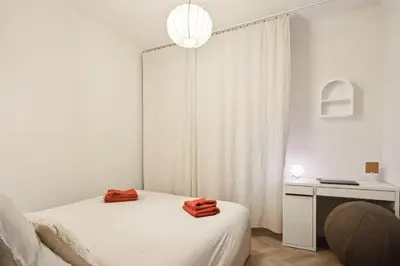 a white bedroom with a bed and a desk and a lamp at Cosy moon for 4 or 6 people quartier du Port in Nice