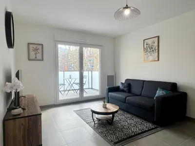 a living room with a couch and a table at Brand new flat with terrace and parc view in Nice