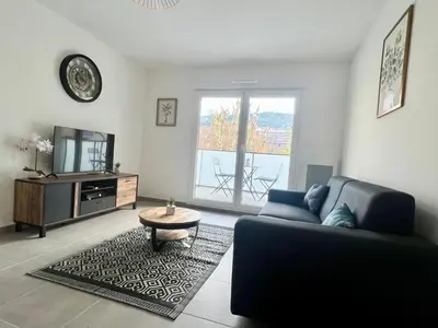 a living room with a couch and a tv at Brand new flat with terrace and parc view in Nice
