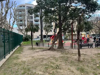 a tree in a park next to a fence at Brand new flat with terrace and parc view in Nice