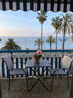a table and chairs on a balcony with the ocean at Nice Promenade des Anglais Your Seafront Flat in Nice