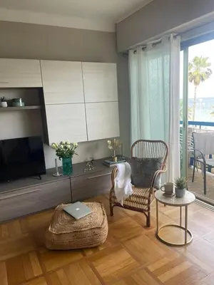 a living room with a tv and a chair and a table at Nice Promenade des Anglais Your Seafront Flat in Nice