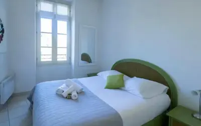 a bedroom with a bed with two towels on it at Place Grimaldi, close to beach and restaurants, with balcony in Nice
