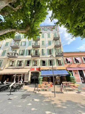 a large building with tables and chairs in front of it at Place Grimaldi, close to beach and restaurants, with balcony in Nice