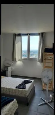 a bedroom with two beds and two windows at Grand Appartement 5 chambres, 5 télévision , 95 m2, vue mer, tramway sur place, gare train 2 min, aéroport 5 min , Large Apartment 5 bedrooms, 5 televisions, 95 m2, sea view, tram on site, train station 2 mins, airport 5 mins in Nice