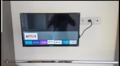 a television is attached to a white wall at Grand Appartement 5 chambres, 5 télévision , 95 m2, vue mer, tramway sur place, gare train 2 min, aéroport 5 min , Large Apartment 5 bedrooms, 5 televisions, 95 m2, sea view, tram on site, train station 2 mins, airport 5 mins in Nice
