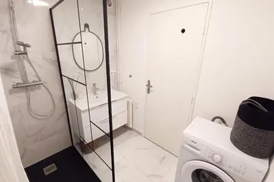 a bathroom with a shower and a washing machine at 2-rooms apartment with Wifi and balcony in Nice