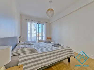 a bedroom with a bed with a striped blanket at Golden Square in Nice