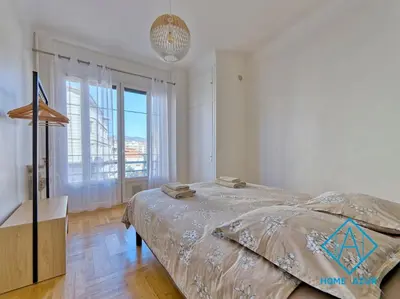 a bedroom with a bed and a large window at Golden Square in Nice