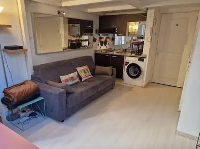 a living room with a couch and a kitchen at Carré d'Or Star Loft in Nice