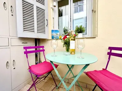 a table with two chairs and two wine glasses at Syrah - Cozy Apartment in Nice