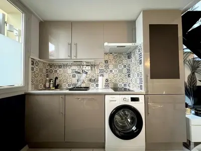 a kitchen with a washing machine and a washer at Syrah - Cozy Apartment in Nice