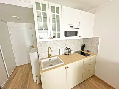 a kitchen with white cabinets and a sink and a refrigerator at Stunning Studio Rue France Promenade des Anglais in Nice