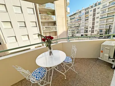 a table and chairs on a balcony with buildings at Stunning Studio Rue France Promenade des Anglais in Nice