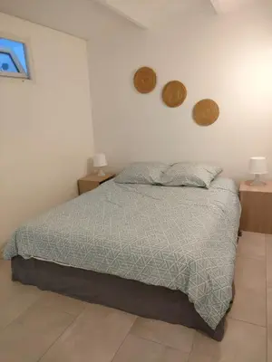 a bed in a bedroom with two night stands and two lamps at Appartement 2 pieces à Beaulieu-sur-Mer in Beaulieu-sur-Mer