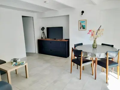 a living room with a table and chairs and a tv at Appartement 2 pieces à Beaulieu-sur-Mer in Beaulieu-sur-Mer
