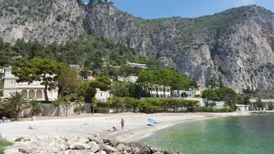 a beach with a group of people on the beach at Appartement 2 pieces à Beaulieu-sur-Mer in Beaulieu-sur-Mer