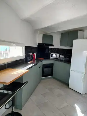 a kitchen with green cabinets and a white refrigerator at Appartement 2 pieces à Beaulieu-sur-Mer in Beaulieu-sur-Mer