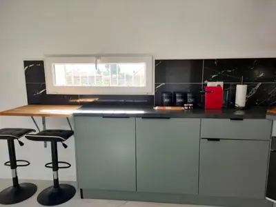 a kitchen with a counter with stools and a window at Appartement 2 pieces à Beaulieu-sur-Mer in Beaulieu-sur-Mer