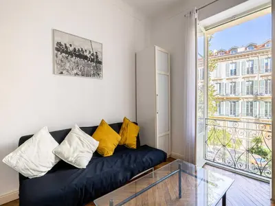 a living room with a black couch and a glass table at Superb 2 room apartment in the heart of Nice in Nice