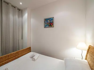 a bedroom with a bed and a picture on the wall at Superb 2 room apartment in the heart of Nice in Nice