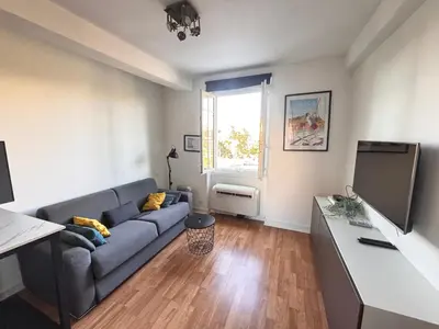 a living room with a couch and a flat screen tv at Studio au cœur de Nice lumineux in Nice