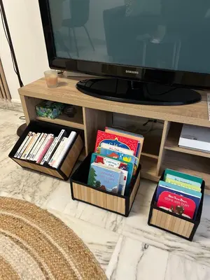 a tv stand with books and a tv at Superbe appartement Port de Nice Lumineux,Clim , Parking in Nice