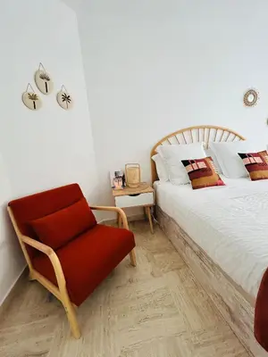 a bedroom with a bed and a red chair at Superbe appartement Port de Nice Lumineux,Clim , Parking in Nice