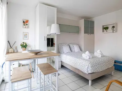 a bedroom with a bed and a table and a desk at Studio with balcony & pool -Heart of Nice in Nice