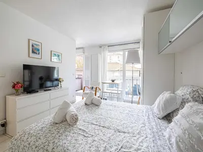a white bedroom with a bed and a tv at Studio with balcony & pool -Heart of Nice in Nice