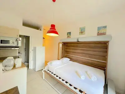 a bedroom with a bed with a wooden headboard at ⁂ Studio cosy 3 min de la plage terrasse clim in Nice