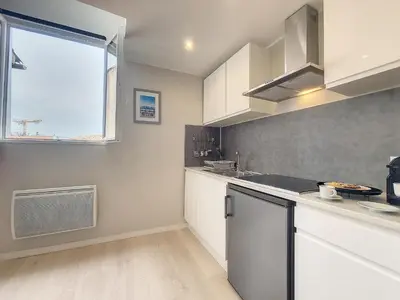 a kitchen with white cabinets and a window at Nestor&Jeeves - VIEUX NICE DUPLEX - Studio - Central in Nice