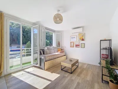 a living room with a couch and a large window at Studio toit terrasse vue mer Sea View in Nice