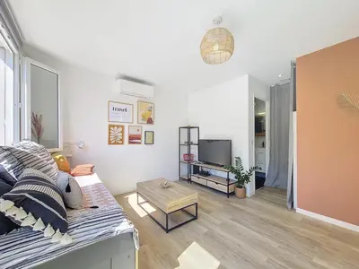 a living room with a couch and a tv at Studio toit terrasse vue mer Sea View in Nice