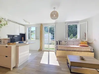 a kitchen with a couch in the middle of a room at Studio toit terrasse vue mer Sea View in Nice