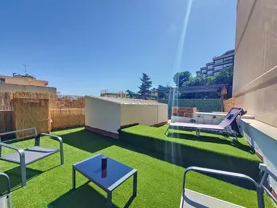 a small rooftop patio with green grass on a building at Studio toit terrasse vue mer Sea View in Nice