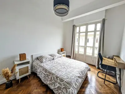 a bedroom with a bed and a large window at Cosy appartement in Nice city center in Nice