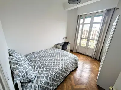 a bedroom with a bed and a large window at Cosy appartement in Nice city center in Nice
