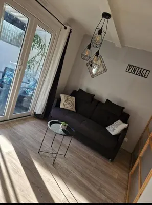 a living room with a black couch and a table at Villa Elisabeth in Nice