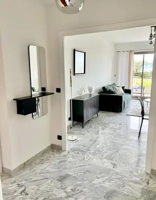 a living room with white walls and a marble floor at Le Grand Soleil in Nice