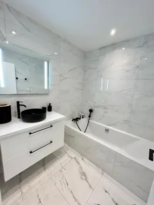 a white bathroom with a tub and a sink at Le Grand Soleil in Nice