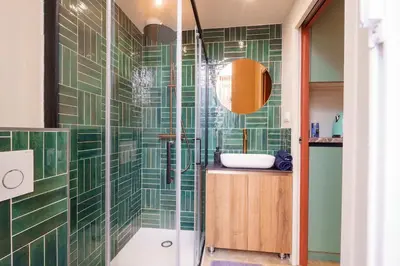 a bathroom with green tiled walls and a shower at Le Jasmin - Au Coeur de Nice in Nice