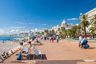 a group of people sitting on benches on the beach at Le Jasmin - Au Coeur de Nice in Nice