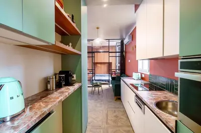 a kitchen with green and white cabinets and a sink at Le Jasmin - Au Coeur de Nice in Nice