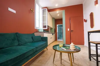 a living room with a green couch and a table at Le Jasmin - Au Coeur de Nice in Nice