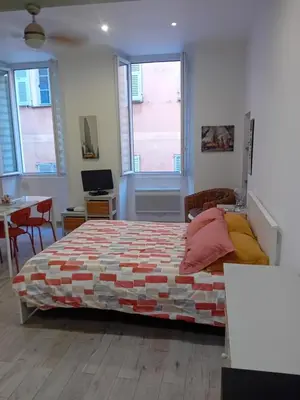 a bedroom with a bed and a desk and two windows at Nice Studio Old Town Sea Side in Nice