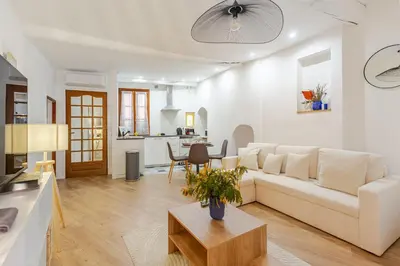 a living room with a white couch and a table at Cocon charmant et paisible au cœur du Vieux Nice in Nice